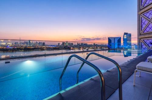 迪拜班达阿炎罗塔纳 - 迪拜河酒店的一座城市天际线建筑的顶部游泳池