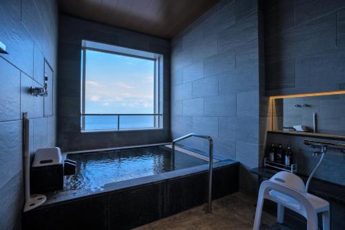 别府AMANE resort SEIKAI的一间带大浴缸及窗户的浴室