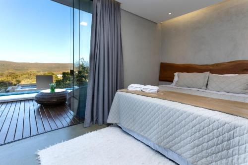 戈亚斯州上帕莱索Villa Azaleia的一间卧室设有一张床和一个美景阳台