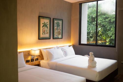 杜马格特Hotel Dumaguete的酒店客房设有两张床和窗户。