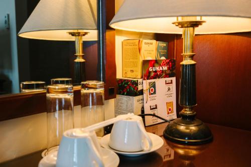 大叻大叻杜帕克酒店的一张桌子,上面有台灯和两个杯子