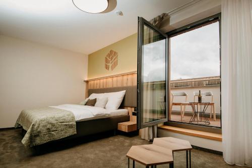 普列维扎RM Hotel Wellness & Congress的一间卧室设有一张床和一个大窗户