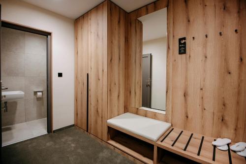 普列维扎RM Hotel Wellness & Congress的配有镜子和淋浴的浴室的长凳