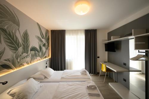 托尔博莱Park Hotel Eden的配有一张床和一张书桌的酒店客房