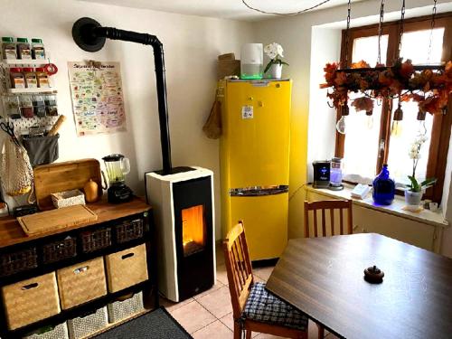 Chironicoin lak'ech - rooms的厨房配有桌子和黄色冰箱