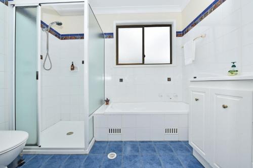 罗斯伯里Silver Springs Estate的带淋浴和盥洗盆的白色浴室