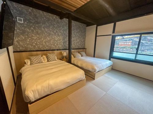 GotsuKototoki - Yu -的一间卧室设有两张床和窗户。