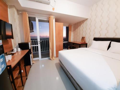 斯勒曼Apartemen Taman Melati Sinduadi By NGINAP的一间卧室配有一张床、一张书桌和一个窗户。
