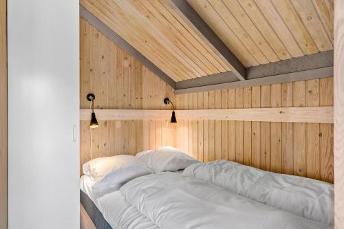 斯卡恩First Camp Råbjerg Mile - Skagen的木墙客房的一张床位