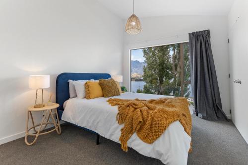 皇后镇Spacious relaxing home的一间卧室设有蓝色的床和大窗户