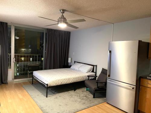 檀香山Marine Surf的一间卧室配有一张床和一台冰箱