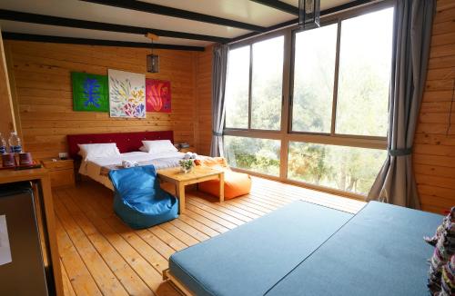 杰津蓝鸟谷住宿加早餐旅馆的一间卧室设有一张床和一个大窗户