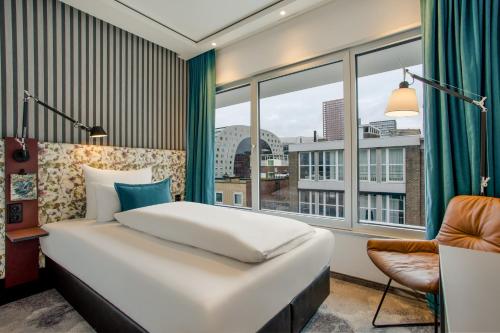 鹿特丹Motel One Rotterdam的一间卧室设有一张床和一个大窗户
