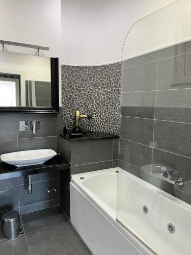 索伦托La meraviglia di Sorrento的浴室配有盥洗盆、浴缸和盥洗盆
