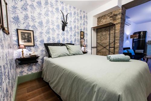 巴伦西纳德拉孔塞普西翁Apartamentos Gaviota的一间卧室配有一张蓝色和白色壁纸的大床