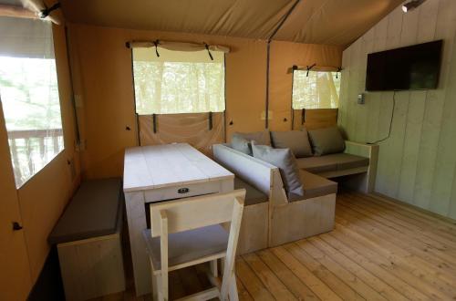 Echarri-AranazCAMPING ETXARRI的一间帐篷内配有沙发和桌子的房间