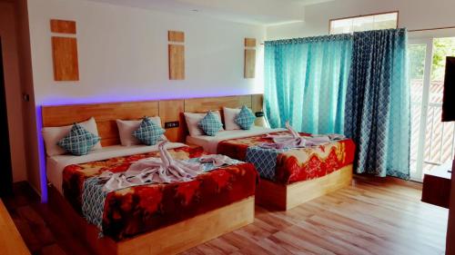 蒙纳Ivy paradise cottage (IV cottage)的卧室内的两张床,配有蓝色窗帘