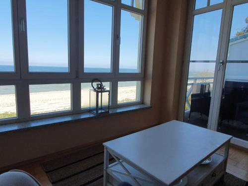 卢布明Maisonettewohnung Strandburg的客房设有桌子和窗户,享有海滩美景