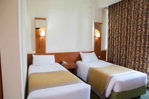 基加利格瑞里斯城市中心酒店的酒店客房,设有两张床和镜子