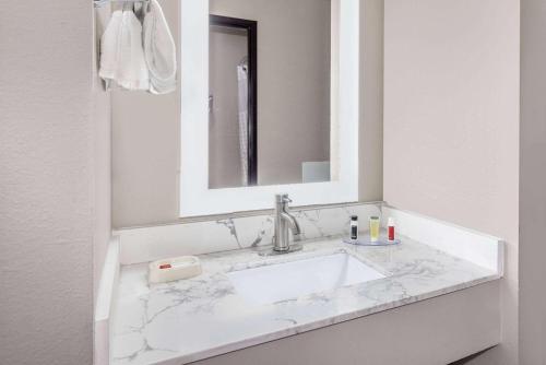 PrattSuper 8 by Wyndham Pratt的白色的浴室设有水槽和镜子