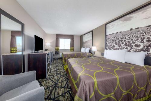 PrattSuper 8 by Wyndham Pratt的酒店客房设有两张床和一台平面电视。