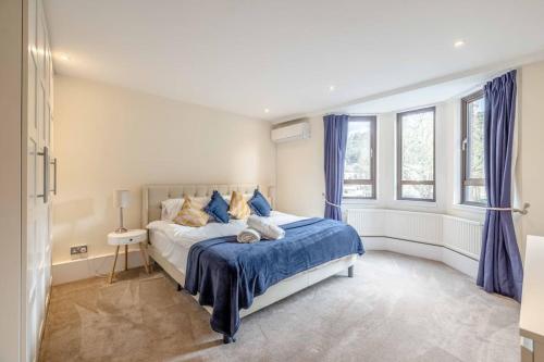 温莎Hidden Gem With Windsor Castle Views & Parking的一间卧室配有一张带蓝色床单和窗户的床。