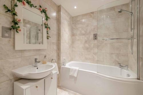 温莎Hidden Gem With Windsor Castle Views & Parking的浴室设有白色浴缸、水槽和浴缸。