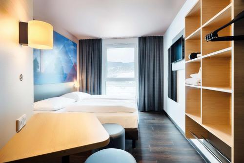 维林根B&B Hotel Willingen的酒店客房配有两张床和一张书桌