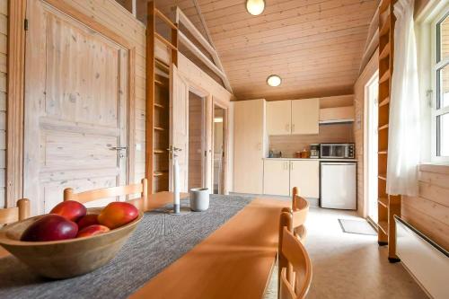 BåringFirst Camp Skovlund Camping & Cottages的厨房里放着一碗苹果放在桌子上