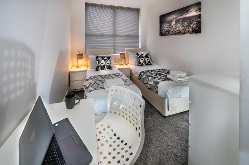 雷丁Modern & spacious 2-bed flat with secure parking的一间卧室配有两张床和一张桌子及椅子