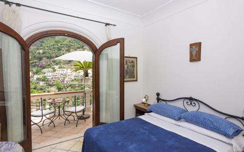 波西塔诺Villa Palumbo的一间卧室配有一张床,阳台配有桌子