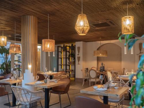 罗塔卡里布酒店的餐厅设有桌椅和吊灯。