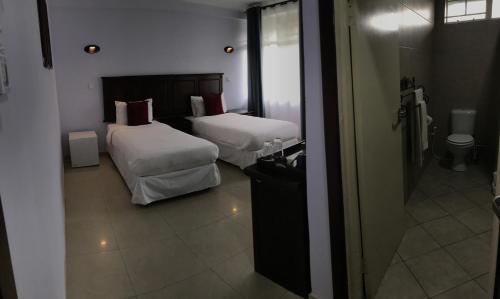 利文斯顿Crescent Lodge的酒店客房,设有两张床和镜子