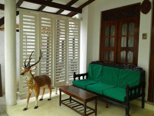 米瑞莎R Home Stay的客厅配有绿色沙发和鹿雕像