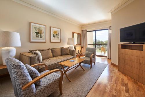丰沙尔梅尔波尔图湾酒店&度假村的带沙发和电视的客厅