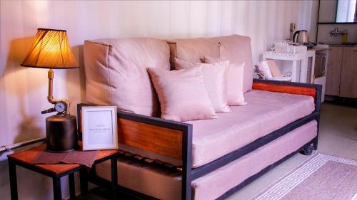 圣贝纳迪诺Don Juan Carlos Cabañas Ecológicas的一张带枕头的沙发和一张桌子上的台灯