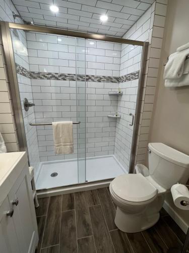 泊鲁威利宾馆的一间带卫生间和玻璃淋浴间的浴室