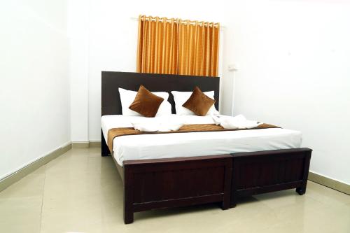 科钦AWA Residency的一间卧室配有一张大床,提供棕色和白色的枕头