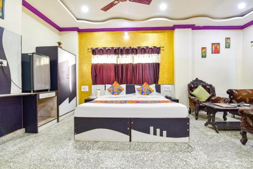 乌代浦FabExpress Relax Inn I, Udaipur的一间卧室配有一张床和一台平面电视