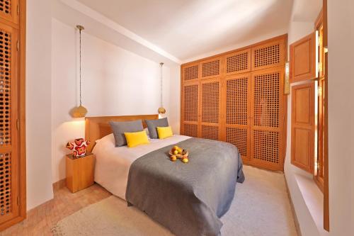 马拉喀什RIAD THE MILESTONE的一间卧室配有黄色和蓝色枕头的床