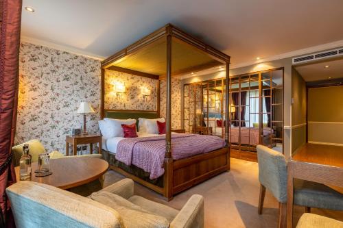 圣奥尔本斯圣迈克尔庄园酒店 - 圣奥尔本斯的一间卧室配有天蓬床和桌椅