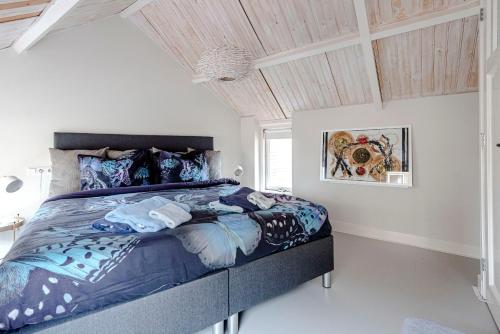 滨海卡特韦克Kusthuiskatwijk的一间卧室配有一张带蓝色棉被的床