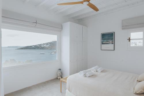 普拉迪斯亚罗斯myMykonos villa II的白色的卧室设有床和大窗户