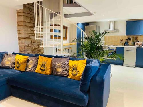 Welsh Newton CommonThe Cider House Holiday Cottage的客厅里配有带黄色枕头的蓝色沙发