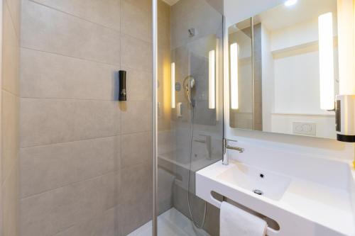 维里埃特B&B HOTELS Bourg-en-Bresse Viriat的带淋浴、盥洗盆和镜子的浴室