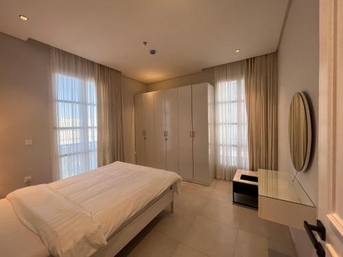 利雅德luxury 3BD Condo Near the Boulevard的卧室配有一张床、一张书桌和窗户。