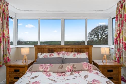 DistingtonComfy Cumbrian Stay的一间卧室设有一张床和两个窗户。