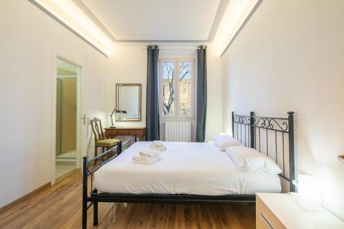 佛罗伦萨Petrarca Apartment的一间卧室配有一张带白色床单和镜子的床