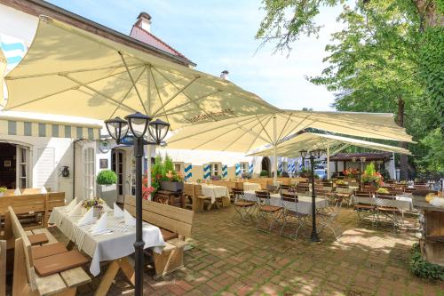 慕尼黑Weichandhof的一个带桌椅和遮阳伞的庭院