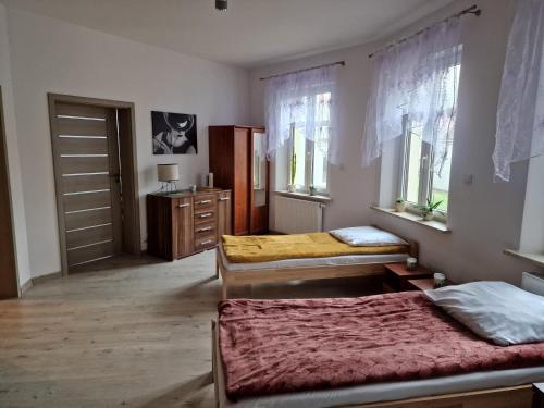 莱希纳Noclegi Leśna的一间卧室设有两张床、一个梳妆台和窗户。